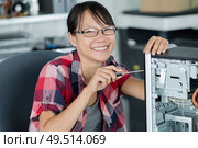 portrait of a smily woman fixing a computer at work. Стоковое фото, агентство Ingram Publishing / Фотобанк Лори