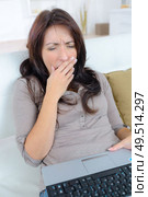 yawing woman on sofa yawning. Стоковое фото, агентство Ingram Publishing / Фотобанк Лори
