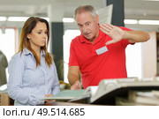 Middle aged man giving instructions to female colleague. Стоковое фото, агентство Ingram Publishing / Фотобанк Лори