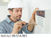 male technician installing an air conditioner. Стоковое фото, агентство Ingram Publishing / Фотобанк Лори
