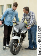 father advising son before using his motorcycle. Стоковое фото, агентство Ingram Publishing / Фотобанк Лори