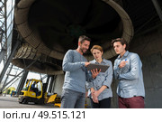 workers looking at tablet pc by industrial silos. Стоковое фото, агентство Ingram Publishing / Фотобанк Лори