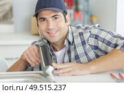 plumber sealing sink with silicone. Стоковое фото, агентство Ingram Publishing / Фотобанк Лори
