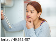 lady looking at water pipes in confusion. Стоковое фото, агентство Ingram Publishing / Фотобанк Лори