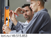 two man wall holding spirit level. Стоковое фото, агентство Ingram Publishing / Фотобанк Лори