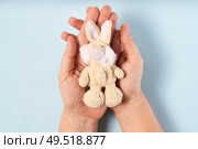 Autism concept with hands holding toy bunny on a blue background. Autism Awareness Day. Autism Spectrum Disorder ASD concept. Autism Spectrum Disorder ASD concept. Стоковое фото, агентство Ingram Publishing / Фотобанк Лори