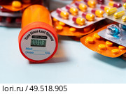 Pile of colorful medical pills in blisters and bottles border on blue background. Drug and antibiotics prescription for treatment medication.. Pile of pills. Стоковое фото, агентство Ingram Publishing / Фотобанк Лори