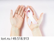 Two holding pink ribbon, symbol of breast cancer awareness. Pink ribbon, symbol of breast cancer awareness. Стоковое фото, агентство Ingram Publishing / Фотобанк Лори