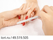 Close up of grinding nails a nail file, isolated. Стоковое фото, агентство Ingram Publishing / Фотобанк Лори