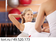 The girl does twisting on fitball with support of the trainer. Стоковое фото, агентство Ingram Publishing / Фотобанк Лори