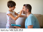 Little cute daughter doing make-up to her father. Dad spending free time with her daughter. Alternative masculinity concept.. Little cute daughter doing make-up to her father. Стоковое фото, агентство Ingram Publishing / Фотобанк Лори