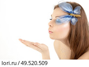 The girl with a make-up of the butterfly blows on a hand, isolated. Стоковое фото, агентство Ingram Publishing / Фотобанк Лори