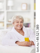 Smiling attractive woman in a bathrobe with a glass of juice. Стоковое фото, агентство Ingram Publishing / Фотобанк Лори