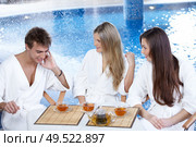 Friends communicate over a cup of tea against pool. Стоковое фото, агентство Ingram Publishing / Фотобанк Лори