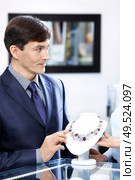 The man of average years in shop chooses a necklace. Стоковое фото, агентство Ingram Publishing / Фотобанк Лори
