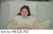 Young adult woman puts down immobile numb hand after sleep because of sleeping with a stretched arm. Стоковое видео, видеограф Денис Кебедов / Фотобанк Лори