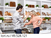 The young couple quarrels in a baker?s shop. Стоковое фото, агентство Ingram Publishing / Фотобанк Лори