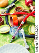 Arabic smoking hookah with taste of kiwi.Fruit shisha tobacco. Tobacco with taste of kiwi.Oriental tobacco hooka. Fragrant smoking hookah with kiwi. Стоковое фото, агентство Ingram Publishing / Фотобанк Лори