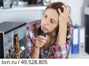 frustrated woman fixing a computer. Стоковое фото, агентство Ingram Publishing / Фотобанк Лори