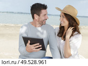 young couple using a digital tablet at seaside town. Стоковое фото, агентство Ingram Publishing / Фотобанк Лори