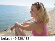 womans nitting on a seawall. Стоковое фото, агентство Ingram Publishing / Фотобанк Лори