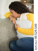 picture of a sad woman sitting on the sofa. Стоковое фото, агентство Ingram Publishing / Фотобанк Лори