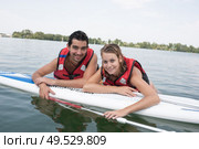 young couple swiming with paddle board in a lake. Стоковое фото, агентство Ingram Publishing / Фотобанк Лори