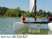 young adults in catamaran canoe. Стоковое фото, агентство Ingram Publishing / Фотобанк Лори