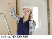 stressed female builder gesticulating while on telephone. Стоковое фото, агентство Ingram Publishing / Фотобанк Лори