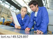 a couple of workers reading the specification. Стоковое фото, агентство Ingram Publishing / Фотобанк Лори