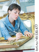 conservator cleaning a golden frame. Стоковое фото, агентство Ingram Publishing / Фотобанк Лори