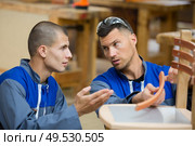 apprentice carpenter discussing broken chair with supervisor. Стоковое фото, агентство Ingram Publishing / Фотобанк Лори