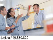 science teacher watching students doing experiment. Стоковое фото, агентство Ingram Publishing / Фотобанк Лори