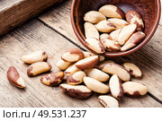 Tasty peeled brazil nut in bowl on old wooden table. Brazil nut or Bertholletia. Стоковое фото, агентство Ingram Publishing / Фотобанк Лори