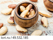 Wooden retro mortar filled with Brazil nut. Brazil nut or Bertholletia. Стоковое фото, агентство Ingram Publishing / Фотобанк Лори