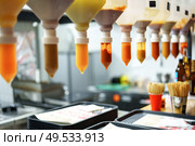 Squeezable condiments hanging in a food service area during a busy mealtime at a casual dining restaurant. Стоковое фото, фотограф Сергей Толмачёв / Фотобанк Лори