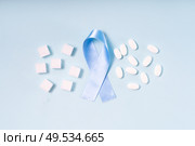 Sugar cubes, Diabetes Awareness Blue Ribbon and pills on plain blue background, flat lay scene. World Diabetes Day concept.. Sugar on blue background. Стоковое фото, агентство Ingram Publishing / Фотобанк Лори
