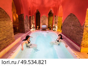 Two women enjoying Arabic baths Hammam in Granada, Andalusia, Spain. Elvira baths. Hot water pool.. Two women enjoying Arabic baths Hammam in Granada. Стоковое фото, агентство Ingram Publishing / Фотобанк Лори