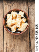 Feta cheese with spice and garlic on old wooden background. Homemade feta cheese with herbs. Стоковое фото, агентство Ingram Publishing / Фотобанк Лори