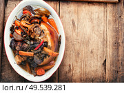 Smoked pork meat knuckle with vegetables on wooden background.Roast pork leg on a wooden board. Pork knuckle on wooden surface. Стоковое фото, агентство Ingram Publishing / Фотобанк Лори