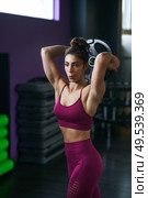 Athletic woman doing triceps push-ups with a barbell plate at the gym.. Athletic woman doing triceps push-ups with a barbell plate. Стоковое фото, агентство Ingram Publishing / Фотобанк Лори