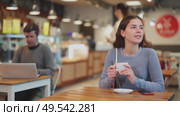Girl whiles away time and waits for meeting in chain cafe. Стоковое видео, видеограф Яков Филимонов / Фотобанк Лори