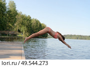 Athletic woman in swimsuit diving headfirst from a pier into the lake. Sunny summer day, dynamic outdoor action. Стоковое фото, фотограф Скоробогатова Е. / Фотобанк Лори