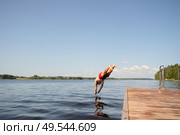 Man diving headfirst from pier into the lake. Strong form, clear water, summer moment. Стоковое фото, фотограф Скоробогатова Е. / Фотобанк Лори