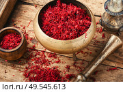 Raw organic red saffron spice on wooden background. Dried saffron spice. Стоковое фото, агентство Ingram Publishing / Фотобанк Лори