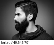 Portrait of handsome man with beard and mustache. Close-up image of serious brutal bearded man on dark background. Black and white photography. Стоковое фото, агентство Ingram Publishing / Фотобанк Лори