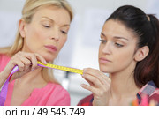 woman with tape measure worried about weight. Стоковое фото, агентство Ingram Publishing / Фотобанк Лори