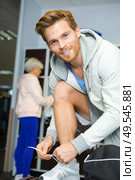 sportsman lacing up his trainers in the chaging room. Стоковое фото, агентство Ingram Publishing / Фотобанк Лори