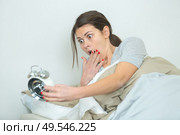 woman in bed looking in shock at alarm clock. Стоковое фото, агентство Ingram Publishing / Фотобанк Лори