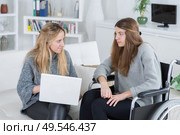 invalid girl on the wheelchair with laptop and her friend. Стоковое фото, агентство Ingram Publishing / Фотобанк Лори